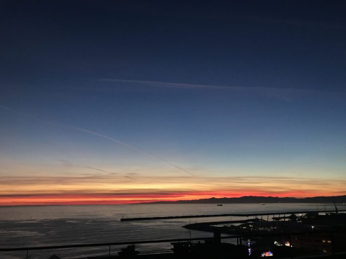 Fotografia del Tramonto da Genova Albaro. L'ingresso della diga foranea a Genova, in fondo i monti dietro Savona.