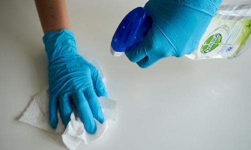 fotografia di mani con guanti e detergente
