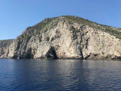 La grotta della Foce Marina nell'isola di Busi in Croazia vista dal mare e come appare da lontano la sua entrata fatta da una fenditura trasversale